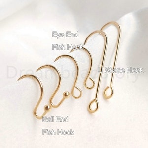 May include: Five gold earring hooks, including a U-shape hook, two fish hooks, an eye end hook, and a ball end hook.