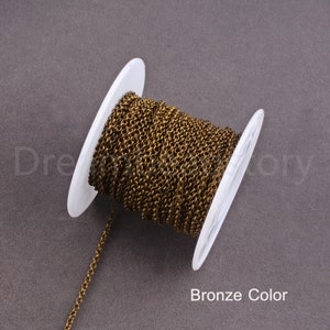 Peut inclure: Une bobine de cha&icirc;ne de couleur bronze, enroul&eacute;e autour d'une bobine en plastique blanc. La cha&icirc;ne est fine et d&eacute;licate.