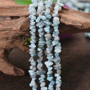May include: A strand of light blue aquamarine chip beads. The beads are irregular in shape and have a natural, tumbled finish.