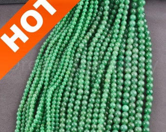 Op de afbeelding: Een streng groene jade kralen, elke kraal is rond en glad. De kralen zijn geregen aan een doorzichtig draad en zijn gerangschikt in een nette, gelijkmatige rij. De kralen zijn lichtgroen van kleur en hebben een lichte glans.