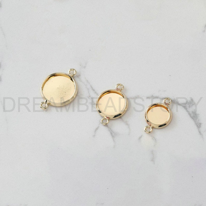 Puede incluir: Tres engastes redondos de metal dorado con dos anillos de salto en cada uno. Los engastes son de diferentes tama&ntilde;os.