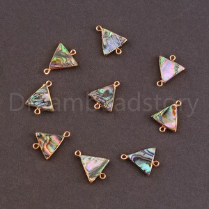 May include: Ten iridescent abalone shell triangle connector charms with gold-toned jump rings. The charms are approximately 1 inch in length.
