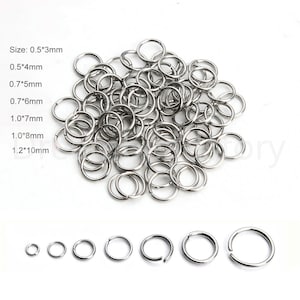 May include: A pile of silver jump rings in various sizes, ranging from 0.5 inches to 1.2 inches in diameter. The jump rings are arranged in a loose pile on a white surface.  Size: 0.5*3mm 0.5*4mm 0.7*5mm 0.7*6mm 1.0*7mm 1.0*8mm 1.2*10mm