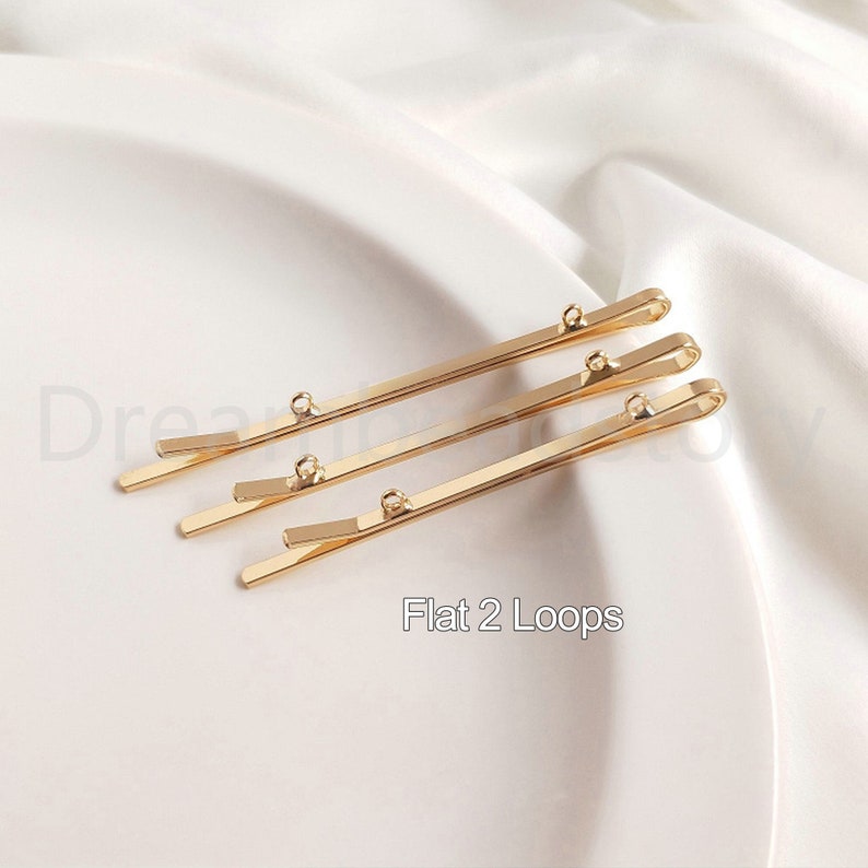 May include: Three gold-colored hair clips with two loops on each clip. The text "Flat 2 Loops" is printed below the clips.