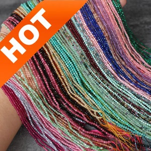 May include: A variety of colorful gemstone beads, including pink, green, blue, and purple, are strung on thin threads. The beads are small and uniform in size, and they are arranged in rows. The image is labeled "HOT" in the upper left corner.