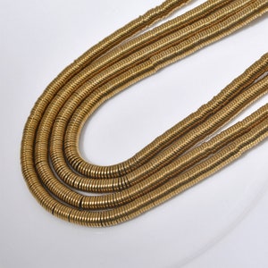 Pu&ograve; includere: Una collana d'oro composta da pi&ugrave; fili di piccole perline rotonde in metallo.