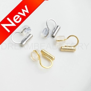 May include: Three pairs of non-pierced ear clips. One pair is gold, one pair is silver, and one pair is a mix of gold and silver. Each clip has a clear silicone pad for a secure fit.
