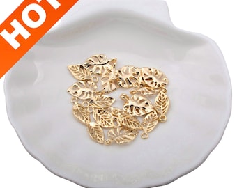 May include: A collection of gold-colored metal leaf charms with a hole at the top for attaching to jewelry or other crafts.