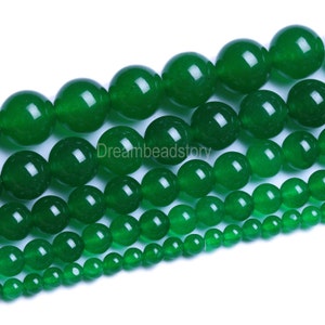 Op de afbeelding: Een streng groene jade kralen in verschillende maten. De kralen zijn rond en glad, met een gepolijste afwerking. De kralen zijn gerangschikt in een aflopend patroon, met de grootste kralen bovenaan en de kleinste kralen onderaan.