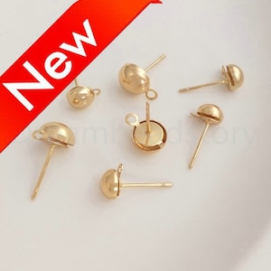 May include: Six gold-toned earring posts with round tops. The posts are designed for attaching charms or other jewelry components.