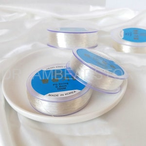 Puede incluir: Tres carretes de hilo el&aacute;stico transparente para hacer joyas. Los carretes est&aacute;n etiquetados con "PU String 0.6mm 100M Made in Korea".