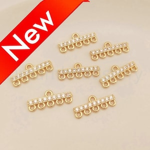 May include: Gold-toned metal connector with five clear crystal stones and four loops. The connector is designed for jewelry making.
