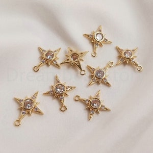 Puede incluir: Un grupo de ocho dijes de estrella de color dorado con acentos de cristal transparente. Cada dije tiene un bucle para sujetarlo a joyas u otras manualidades.