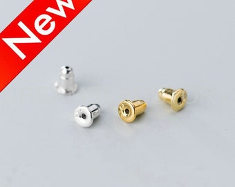 May include: Close-up of several earring backs in silver and gold tones. The earring backs are in focus against a light gray background. A red banner with the word "New" in white is in the upper left corner.