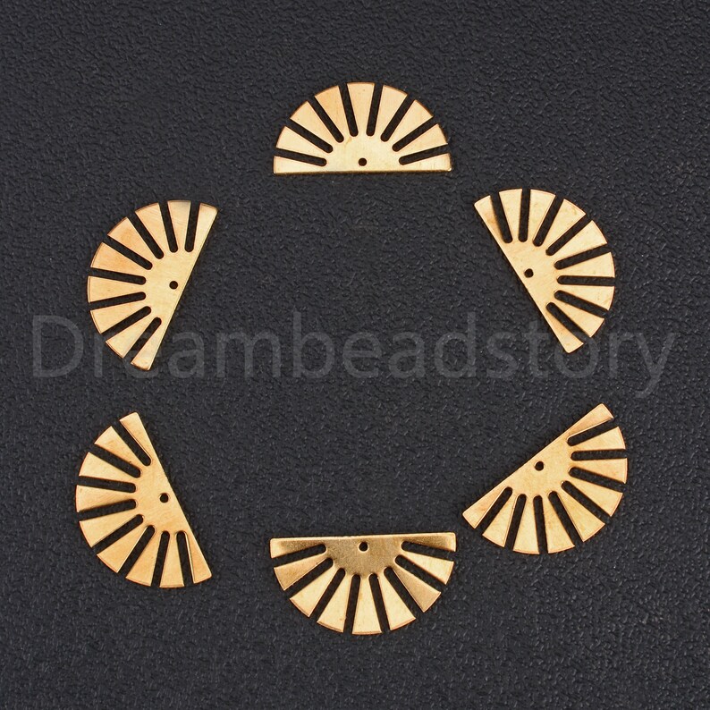 May include: Six gold metal half-circle shapes with a sunburst design. Each shape has a small hole at the top.