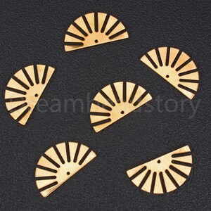 May include: Six gold-colored metal half-circle shapes with a sunburst design. Each shape has a small hole in the center.