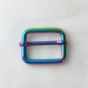 May include: A rainbow iridescent metal slider buckle for a strap or belt.