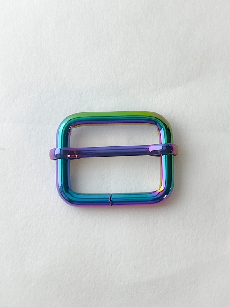 May include: A rainbow iridescent metal slider buckle for a strap or belt.