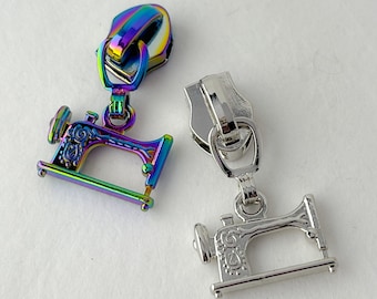 May include: Two zipper pulls with sewing machine charms. One pull is silver and the other is iridescent.