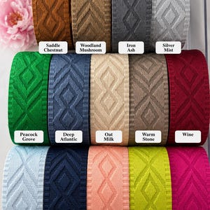 K&ouml;nnte beinhalten: Eine Sammlung von dreizehn Rollen gewebtem Band mit einem sich wiederholenden Rautenmuster. Die Farben sind beschriftet als Saddle Chestnut, Woodland Mushroom, Iron Ash, Silver Mist, Peacock Grove, Deep Atlantic, Oat Milk, Warm Stone, Wine, Winter Cloud, Midnight Blue, Sunset Petal, Citrus Glow und Raspberry Pop.