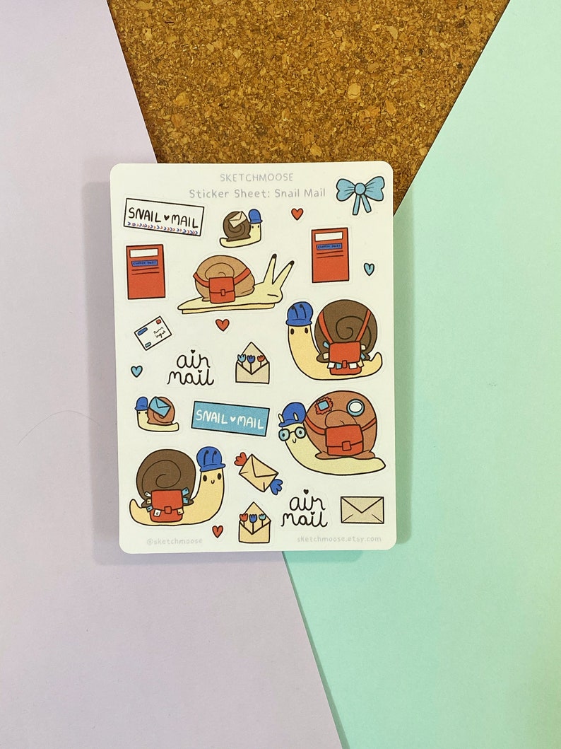 May include: A sticker sheet with a white background featuring snail mail themed illustrations. The sheet includes snails carrying mailbags, envelopes, and mailboxes. The text "Snail Mail" and "Air Mail" is featured on the sheet.