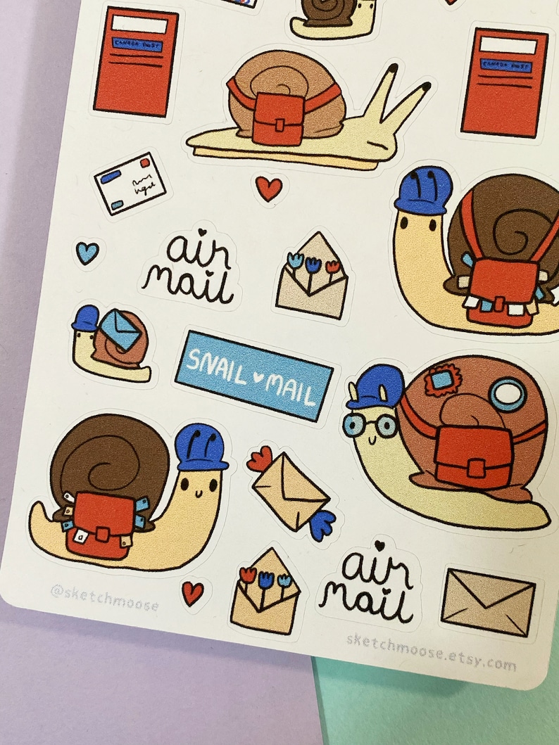 May include: A set of snail mail stickers featuring cute snails wearing blue hats and carrying red mailbags. The stickers also include envelopes, flowers, hearts, and the text "air mail" and "snail mail".