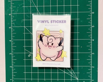Puede incluir: Una pegatina de vinilo con un personaje de dibujos animados rosa con una estrella amarilla en la cabeza. La pegatina es resistente a la intemperie y tiene el texto "VINYL STICKER WEATHERPROOF" y "sketchmoose.etsy.com" impreso en ella.