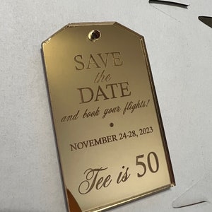 Peut inclure: Carte de save the date en miroir doré avec le texte "SAVE the DATE and book your flights!" et "NOVEMBER 24-28, 2023 Tee is 50".