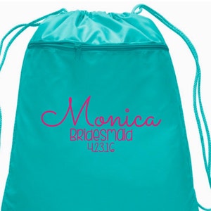 May include: Two turquoise drawstring backpacks. One bag has the name "Ginger" and "Head of Honor" printed in black script. The other bag has the name "Monica" and "Bridesmaid" printed in pink script. Both bags have the number "4231C" printed below the names.