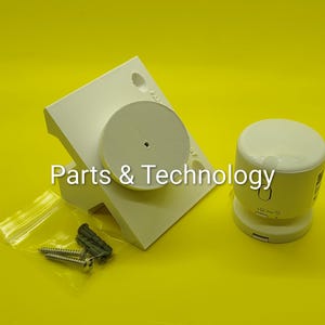 May include: A white plastic wall mount bracket with a circular center, a separate white cylindrical sensor device, and a small clear plastic bag containing two metal screws and two gray plastic wall anchors, with the text Parts & Technology.