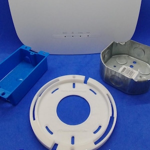 May include: A white NETGEAR INSIGHT wireless access point with a blue plastic junction box, a white plastic mounting ring, and a metal electrical box. The access point has a label with the text "NETGEAR INSIGHT" and a row of four ports labeled "GIG", "A", "2.4GHz", and "5GHz".
