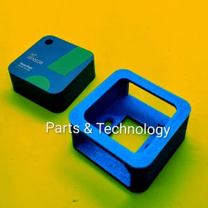 Puede incluir: Dos componentes electrónicos negros y azules sobre un fondo amarillo. Un componente es una caja rectangular con una parte superior azul y un acento verde, etiquetado como "HT SENSOR". El otro es un marco cuadrado azul. También se ve el texto "Parts & Technology".