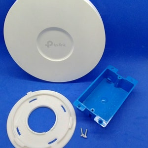 Può includere: Un router wireless bianco da montare a soffitto con una scatola di derivazione in plastica blu e un anello di montaggio in plastica bianca. Il router ha il logo tp-link.