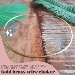 Könnte beinhalten: Goldene Messingdraht-Choker-Kette. Die Kette ist glatt oder gehämmert mit einer spiralförmigen oder geraden Kante.