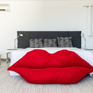 Peut inclure: Un lit blanc avec une tête de lit grise et un oreiller en forme de lèvres rouges dans une chambre moderne.