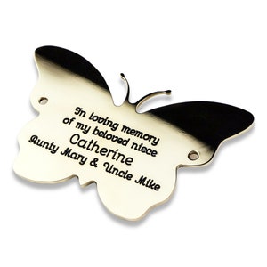 May include: Gold butterfly-shaped memorial plaque with the inscription "In loving memory of my beloved niece Catherine Aunty Mary & Uncle Mike"