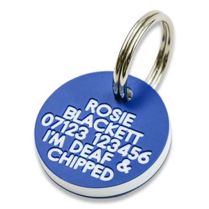 May include: Blue round dog tag with white text that reads "Rosie Blackett 07123 123456 I'm Deaf & Chipped"