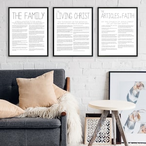 Puede incluir: Tres impresiones enmarcadas en blanco y negro con texto blanco sobre una pared de ladrillo blanco. Las impresiones se titulan "The Family", "The Living Christ" y "The Articles of Faith".