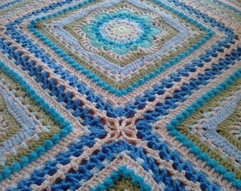 Manta de bebé de ganchillo de estilo tradicional: hilo acrílico azul, verde y gris.