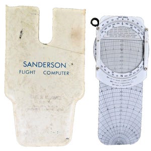 May include: A white plastic case with the text "Sanderson Flight Computer" printed on it. The case is designed to hold a circular flight computer with a white face and black markings. The flight computer has a rotating dial and a sliding ruler.