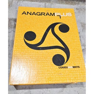 Puede incluir: Una caja de juego de mesa titulada "Anagram Plus" con un diseño en negro y amarillo. La caja presenta el título del juego en letras grandes y un gráfico estilizado. El texto "L'ENJEU DES MOTS" también es visible.