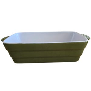 Peut inclure: Un plat de cuisson rectangulaire avec un extérieur vert olive brillant et un intérieur blanc lisse. Le plat présente un design latéral étagé et deux poignées intégrées sur les côtés courts, offrant une esthétique fonctionnelle et épurée.
