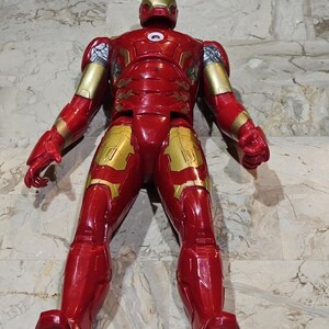 Pu&ograve; includere: Figurina di Iron Man rossa e dorata con finitura metallica. La figura &egrave; in piedi con le braccia distese.