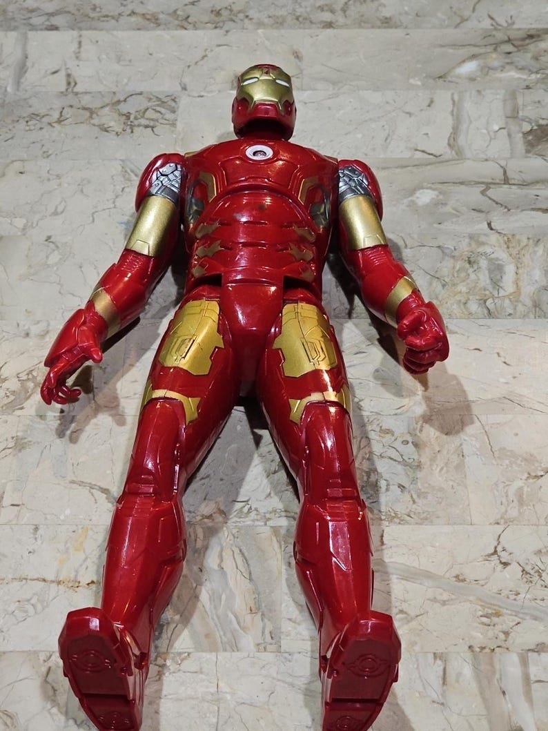 Pu&ograve; includere: Figurina di Iron Man rossa e dorata con finitura metallica. La figura &egrave; in piedi con le braccia distese.