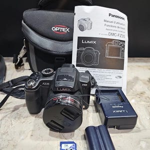 Puede incluir: Una cámara digital Lumix DMC-FZ35 negra con accesorios, que incluyen un cargador, batería, tarjeta SD y una funda de transporte Optex. La cámara tiene los logotipos de Lumix y HD. También se incluye un manual.