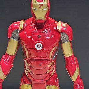 Pu&ograve; includere: Figurina di Iron Man rossa e dorata con un petto che si illumina. La figura &egrave; dettagliata ed &egrave; in posa con le braccia distese.
