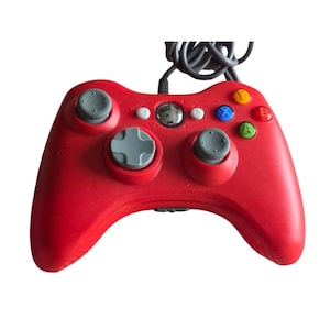 Può includere: Un controller per videogiochi rosso con cavo dotato di due levette analogiche grigie, un pad direzionale grigio e quattro pulsanti azione colorati etichettati Y, X, B e A. Il controller include un pulsante centrale argentato e due tasti grigi Back e Start.