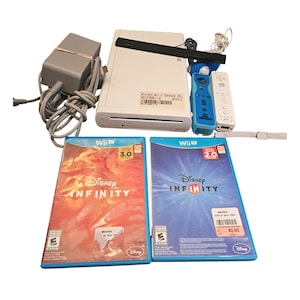 Puede incluir: Una consola Wii blanca con dos mandos, una barra de sensores y dos carcasas de juegos de Disney Infinity. Los juegos están etiquetados como Edición 3.0 y 2.0. También se incluye un adaptador de corriente.