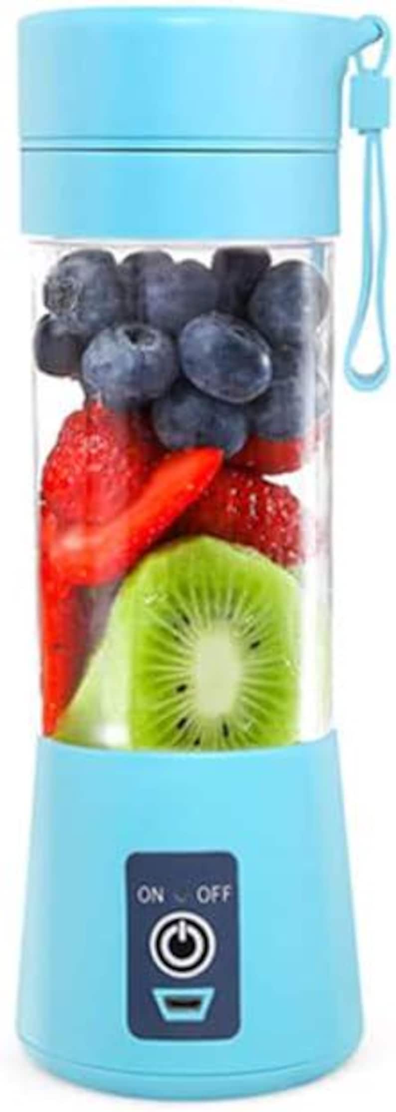 Pu&ograve; includere: Un frullatore portatile blu con un contenitore trasparente pieno di mirtilli, fragole e kiwi. Il frullatore ha un interruttore on/off e una porta di ricarica.