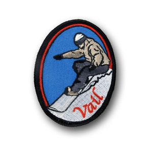 Könnte beinhalten: Ein gestickter Aufnäher mit einem Snowboarder in einer blau-weißen Landschaft mit dem Wort "Vail" in roten Buchstaben.